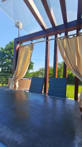 a table and two blue chairs on a patio at Domek PodMaglem in Glinik Polski