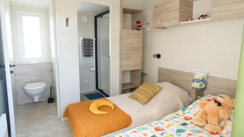 una piccola camera da letto con un letto e un bagno di Camping Les Brillas a Les Moutiers