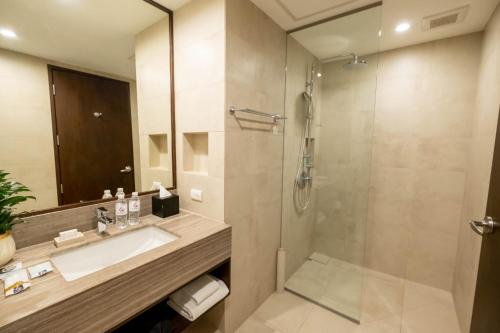 a bathroom with a sink and a shower at Wynwood Hotel in Manila