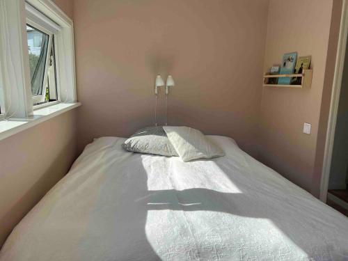 a bed with two pillows in a room with a window at Villa with spectacular sea view in Öckerö