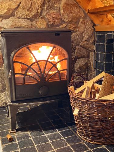 a stone fireplace with a fire in it at Chatka Trapera in Bielice