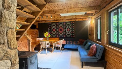 a living room with a blue couch and a table at Chatka Trapera in Bielice