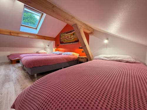 a room with two beds in a attic with a window at Chatka Trapera in Bielice