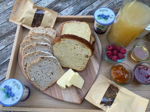 una bandeja con pan y queso y un vaso de jugo de naranja en La Yourte contemporaine de M, en Saint-Pierre-Eynac