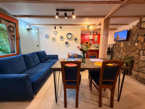 a living room with a blue couch and a table at Chatka Trapera in Bielice