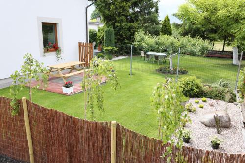 a garden with a fence and a table and bench at Hostel w ogrodzie in Grudziądz