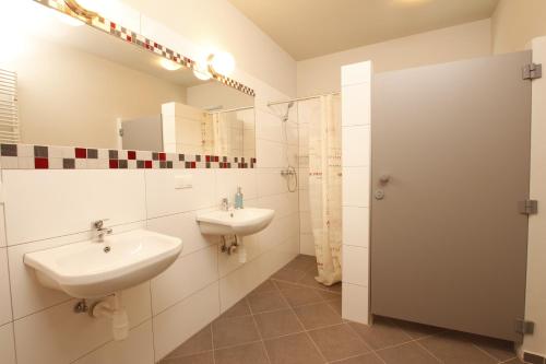 a bathroom with two sinks and a mirror at Hostel w ogrodzie in Grudziądz