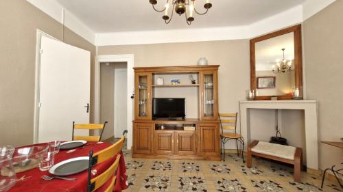 un salon avec une table et une télévision dans l'établissement St Georges de Didonne - MAISON en plein CENTRE-VILLE - PROCHE PLAGE, à Saint-Georges-de-Didonne