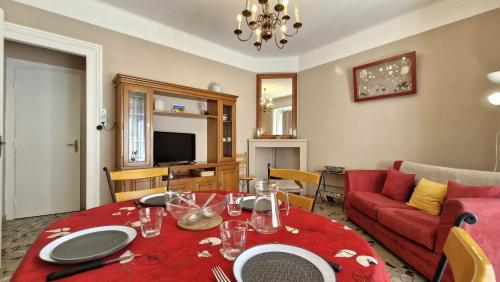 - un salon avec une table rouge et un canapé rouge dans l'établissement St Georges de Didonne - MAISON en plein CENTRE-VILLE - PROCHE PLAGE, à Saint-Georges-de-Didonne