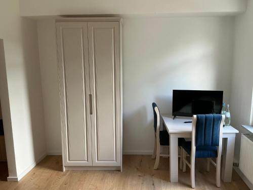 a white cabinet next to a desk with a computer at Hotel &Restaurant Meteora in Glauchau