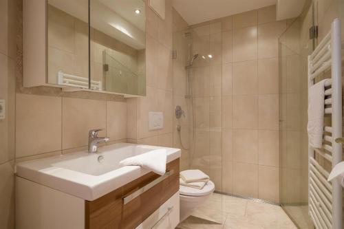 a bathroom with a sink and a toilet and a shower at Ferienhaus Evi - Sonnbichl in Brixen im Thale