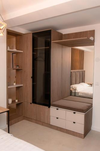 a bedroom with a bed and a large mirror at I&I Apartments Lux in Kragujevac