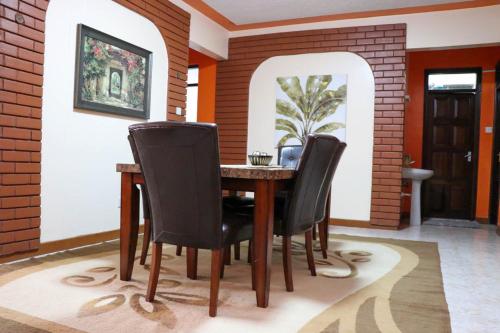 a dining room with a table and black chairs at Patty in Nairobi