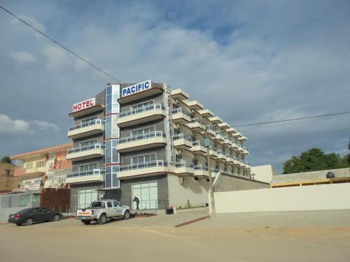 a hotel with a truck parked in front of it at Hotel Pacific, Lda in Cidade de Nacala
