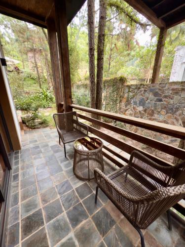 a porch with two benches and a trash can at AMAYA HOME - Lodge, Spa & Restaurant in Hanoi