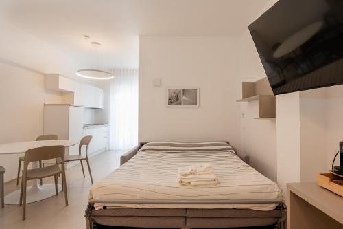a small bedroom with a bed and a table at Agorà Vieste Rooms & Apartments in Vieste