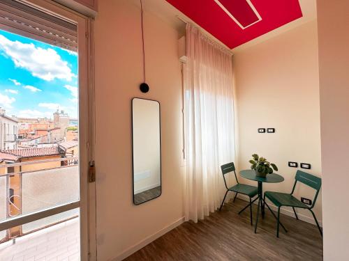 a room with a table and chairs and a window at Ostello Bello Bologna in Bologna