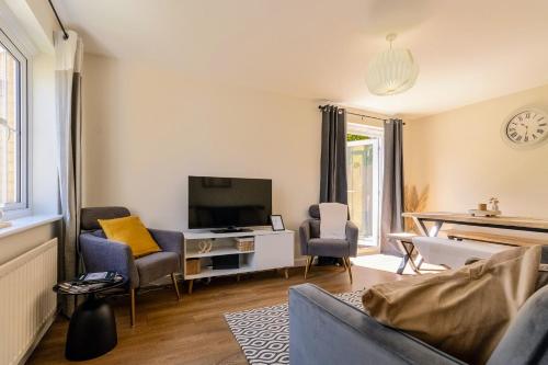a living room with a couch and a tv at Modern & comfy 4 bedrooms Corby house free parking in Great Oakley