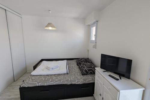 une petite chambre avec un lit et une télévision à écran plat dans l'établissement Pleasant seaside studio, à Les Sables-dʼOlonne