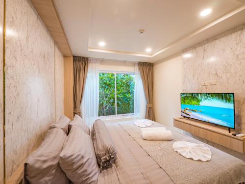 a bedroom with a large bed and a flat screen tv at Lamai Beach - Apartment Leo in Nathon Bay