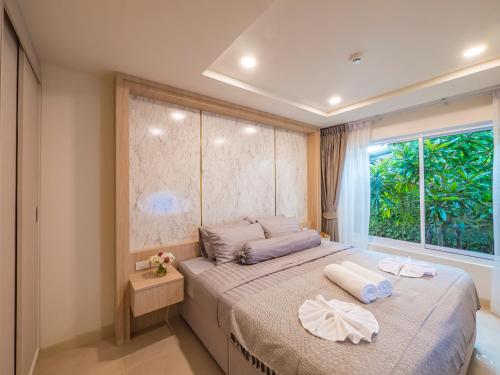 a bedroom with a large bed with a window at Lamai Beach - Apartment Leo in Nathon Bay
