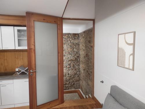 an open door in a kitchen with a stone wall at Casa da Capela in Folgosa