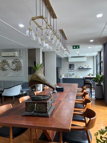 a long table in a room with chairs and lights at Poshtel 56 in Bangkok