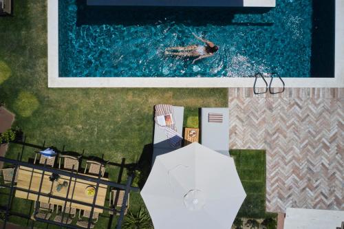 a person swimming in a pool next to a house at Arcasa Villas Collection by Omilos Hotels in Archanes