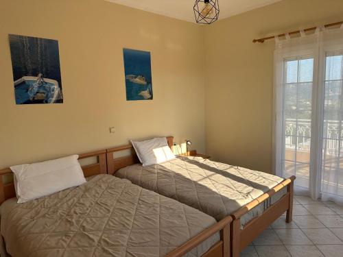 una camera da letto con due letti singoli e una finestra di Sunsets and large pool in comfy Villa Avra Arillas a Arillas