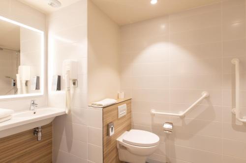a white bathroom with a toilet and a sink at Campanile Metz Centre - Gare in Metz