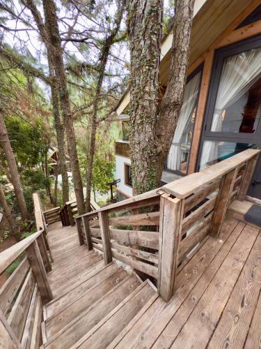 a wooden deck with a fence and a tree at AMAYA HOME - Lodge, Spa & Restaurant in Hanoi