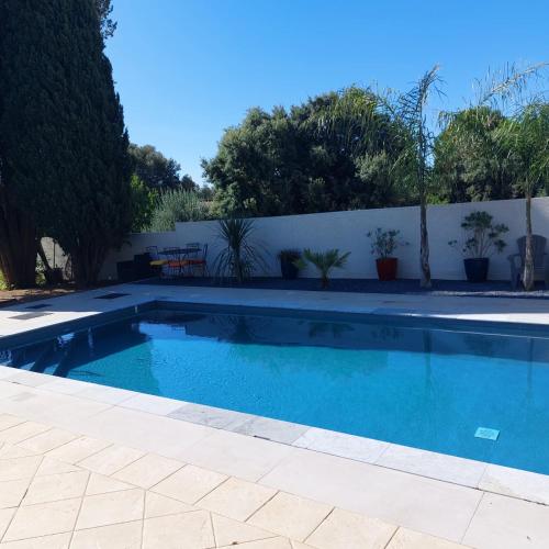 - une piscine dans une cour avec une clôture blanche dans l'établissement Appartement 50m2 au cœur de sussargues, à Sussargues