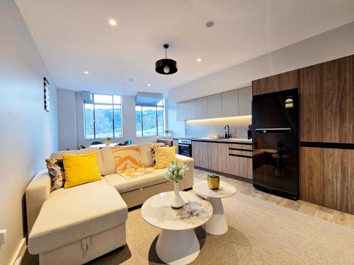 a living room with a couch and a kitchen at Central Lower Hutt 2BR Stay in Lower Hutt