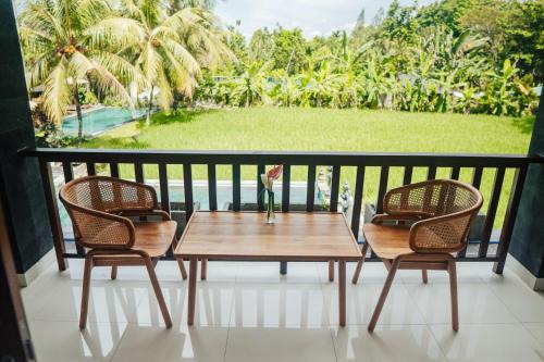 a table and two chairs on a balcony with a view at Tropical Space in Ubud