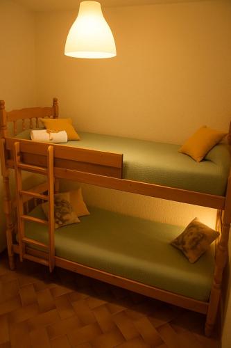 Ce lit se trouve dans un dortoir doté de 2 lits superposés et d'une lampe. dans l'établissement Appartement lumineux avec loggia, vue sur le port, CARNON PLAGE, à Carnon-Plage