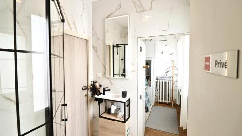 a bathroom with a mirror and a sink at La chambre COCTEAU in Asnières-sur-Seine