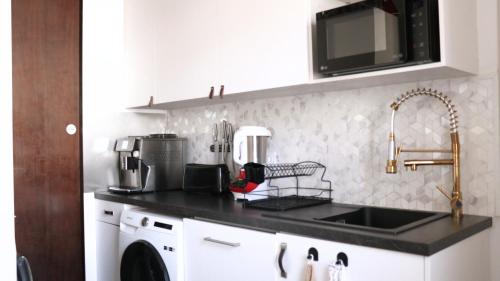 a kitchen with a sink and a counter top at La chambre COCTEAU in Asnières-sur-Seine