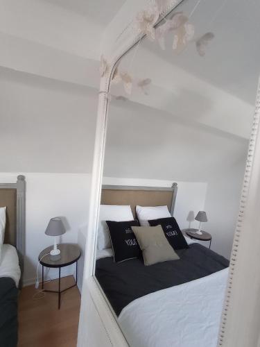 - une chambre avec un lit blanc et des oreillers noirs et blancs dans l'établissement Le Cocon appartement proche Epernay et Maisons de Champagne, à Ay