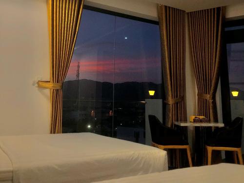 a bedroom with a window with a view of the city at Hilaria Hotel in Vạn Ninh