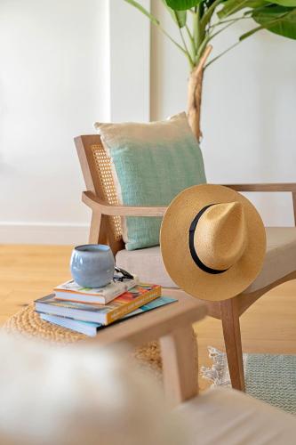 a hat sitting on a chair with books on a table at Finest Retreats - Firethorn in Bude