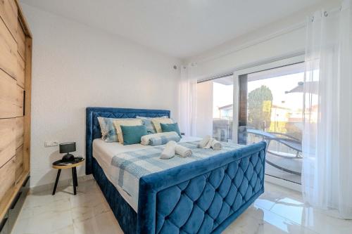 a blue bed in a room with a large window at Apartment Midi in Vir