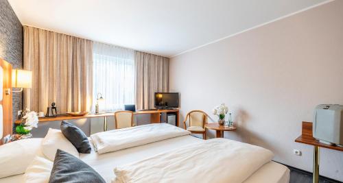 a hotel room with two beds and a television at Best Western Plaza Hotel Zwickau in Zwickau
