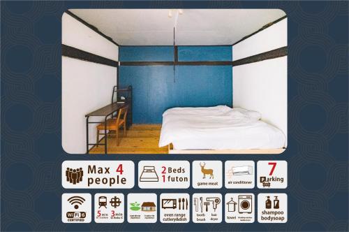 a room with a bed with a blue wall at hinatabocco guesthouse kominka Twin room bed in Miyaki