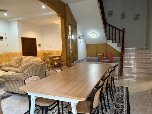 a dining room with a wooden table and chairs at Casa D' Bernam in TanjongMalim
