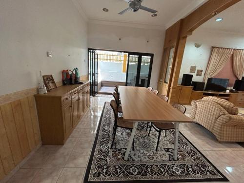 a kitchen and dining room with a table and a couch at Casa D' Bernam in TanjongMalim