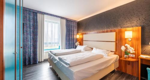 a bedroom with a bed and a large window at Best Western Plaza Hotel Zwickau in Zwickau