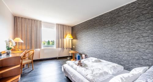 a hotel room with a bed and a table and a desk at Best Western Plaza Hotel Zwickau in Zwickau