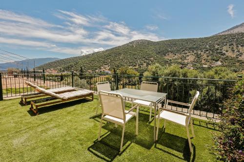 a patio with a table and chairs and mountains at Nikos and Vicky's House in Kefalonia