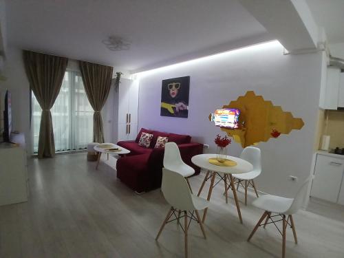 a living room with a red couch and a table at DML Apartment in Mamaia Nord