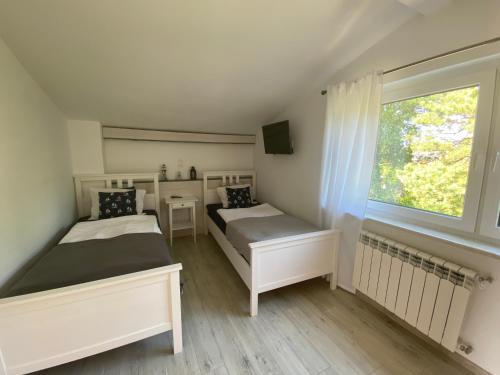Leśne Apartamenty في هيل: سريرين في غرفة بها نافذة